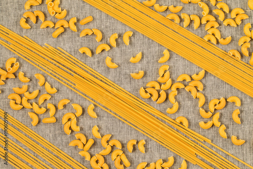 Assortment of different shape pastas on wooden background. photo