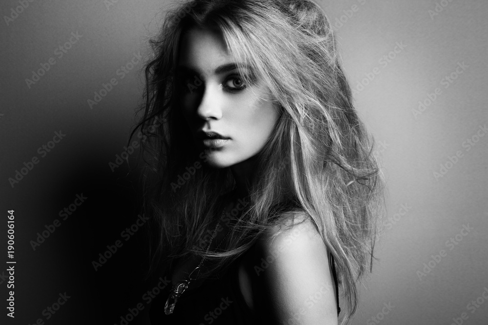 Fototapeta premium Portrait of young beautiful girl with blonde hair. Fashion photo. Hairstyle. Make up. Vogue Style. Black and white photo