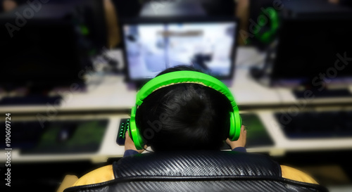 Stressed gamer while playing computer games until morning at internet cafe, game addiction concept, gamer lifestyle