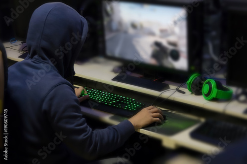 Gamer playing computer games until morning at internet cafe, game addiction concept, gamer lifestyle.