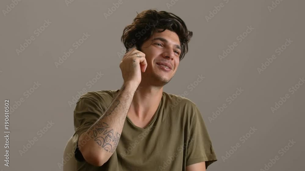 smiling Beautiful young man talking by phone smiling Beautiful young man talking by phone