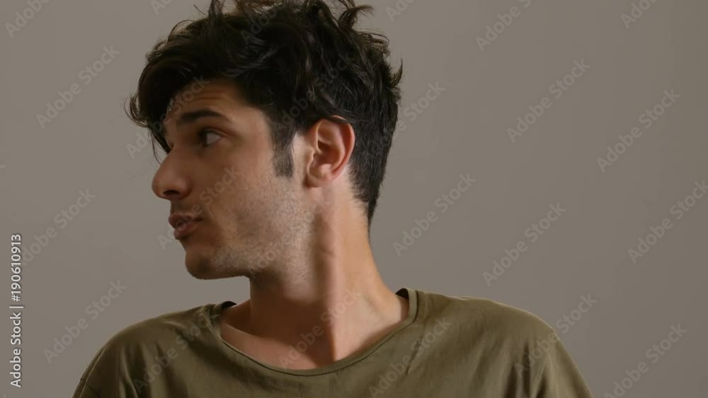 young handsome man looking around and smiles at camera young handsome man looking around and smiles at camera
