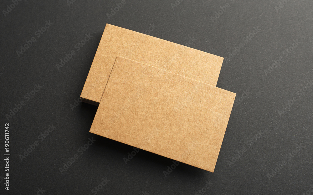 Brown business cards on black background. Mockup.