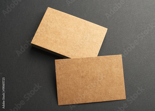Brown business cards on black background. Mockup.