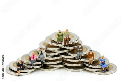 Miniature people : sitting on stack of coins. Isolated on white background,Business Financial, money concept.