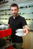 Men barista hold coffee cup. Serving a client.