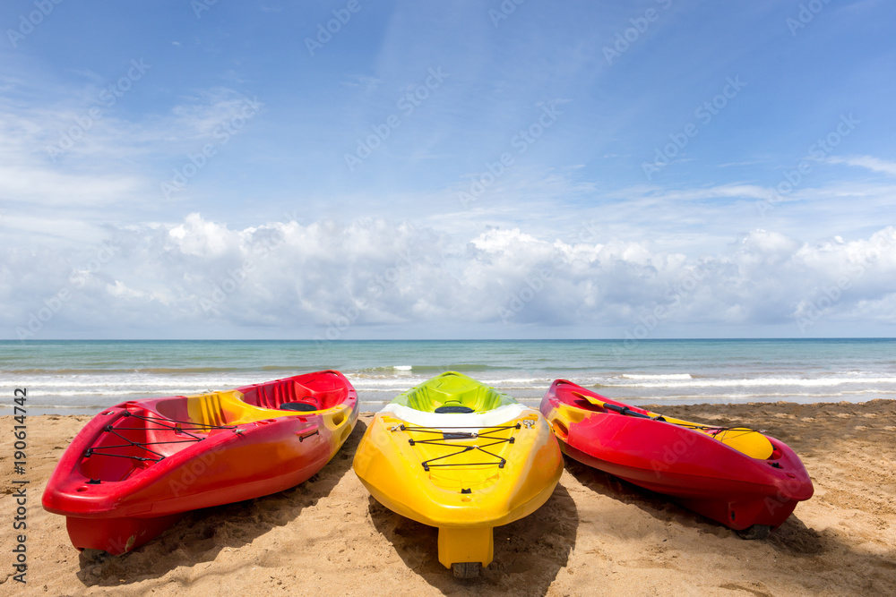 Colorful sea kayaks on sand beach and ocean