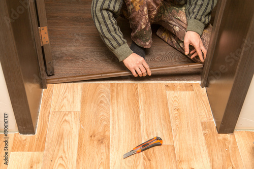 A man is making a threshold on the floor photo