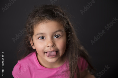 Portrait of lovely baby girl sticking tongue out