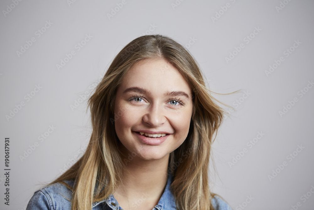 Naklejka premium Smiling girl looking at camera in studio