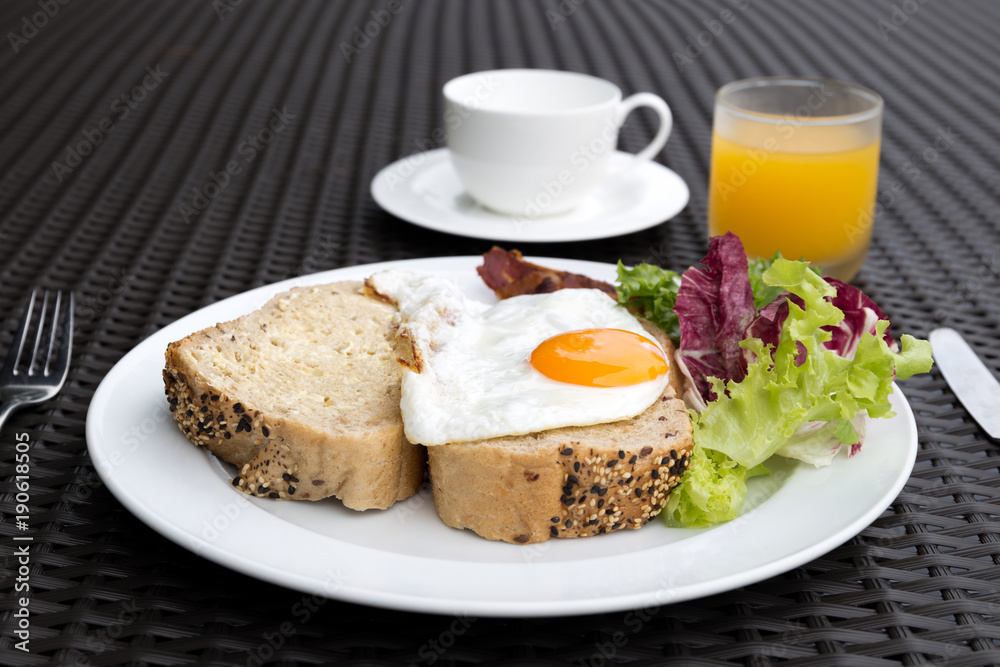 Breakfast set with fried eggs,vegetable,bread,coffee and orange juice