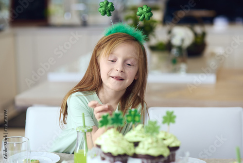 Cheerful girl reaching for cupcake . photo