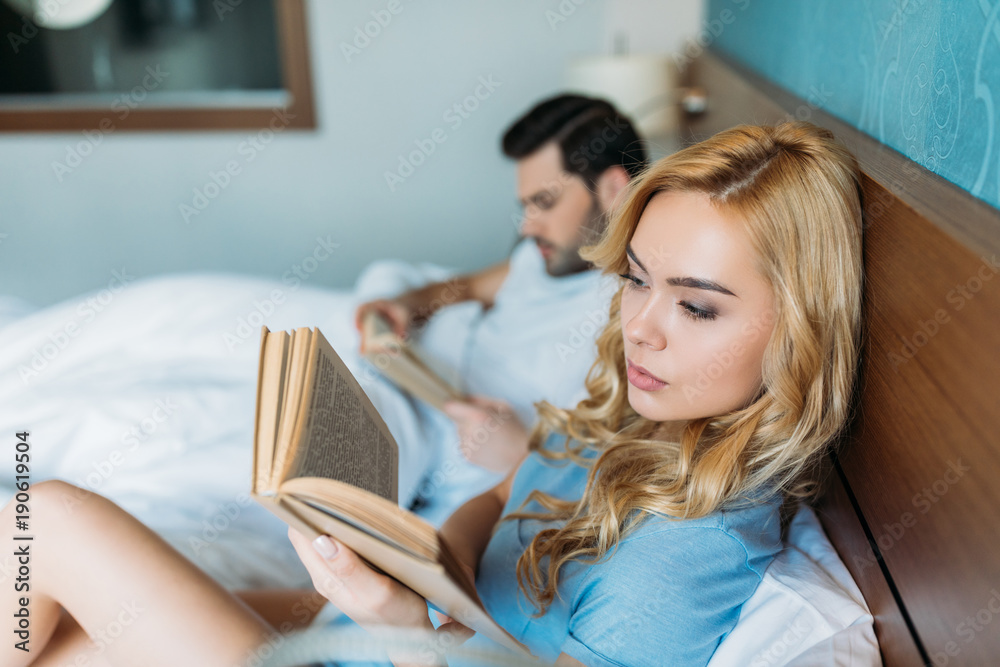 heterosexual couple reading books in bed heterosexual couple reading books in bed