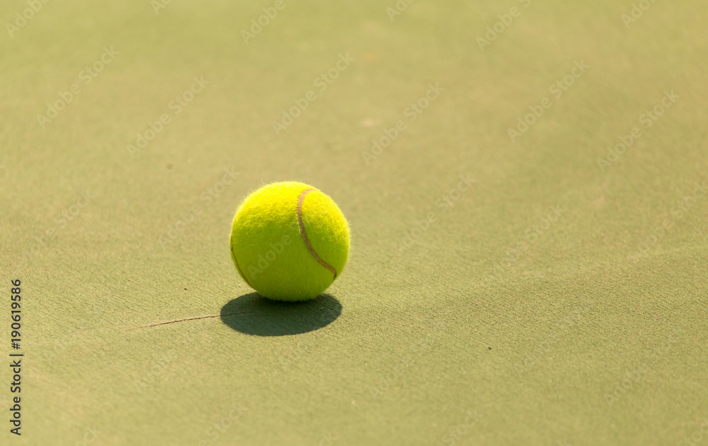 green tennis ball lies on the court