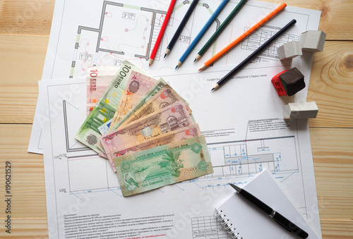 Arab dirhams and euros against the background of an architectural project. 