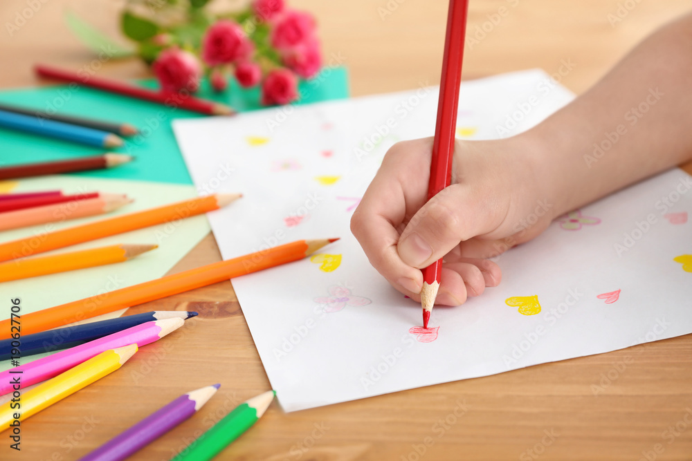 Little girl preparing greeting card for her mommy on Mother's Day at table Little girl preparing greeting card for her mommy on Mother's Day at table
