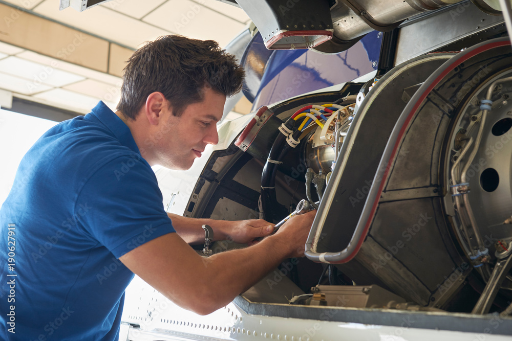 Female Aero Engineer Working On Helicopter In Hangar Female Aero Engineer Working On Helicopter In Hangar