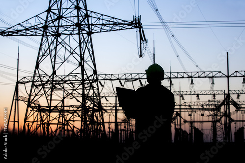 Electricity workers and pylon silhouette