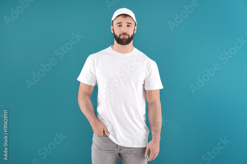 Handsome young man in stylish white t-shirt on color background. Mockup for design