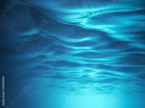 Background of blue wavy water view from below