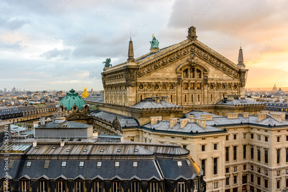 Fototapeta premium Rear view of the Opera Garnier at sunset in Paris, France, showing the northern pediment of the stage house overlooking the administration offices and the slate roofs of the surrounding buildings.