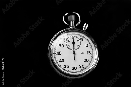 Old stopwatch isolated on black background top view