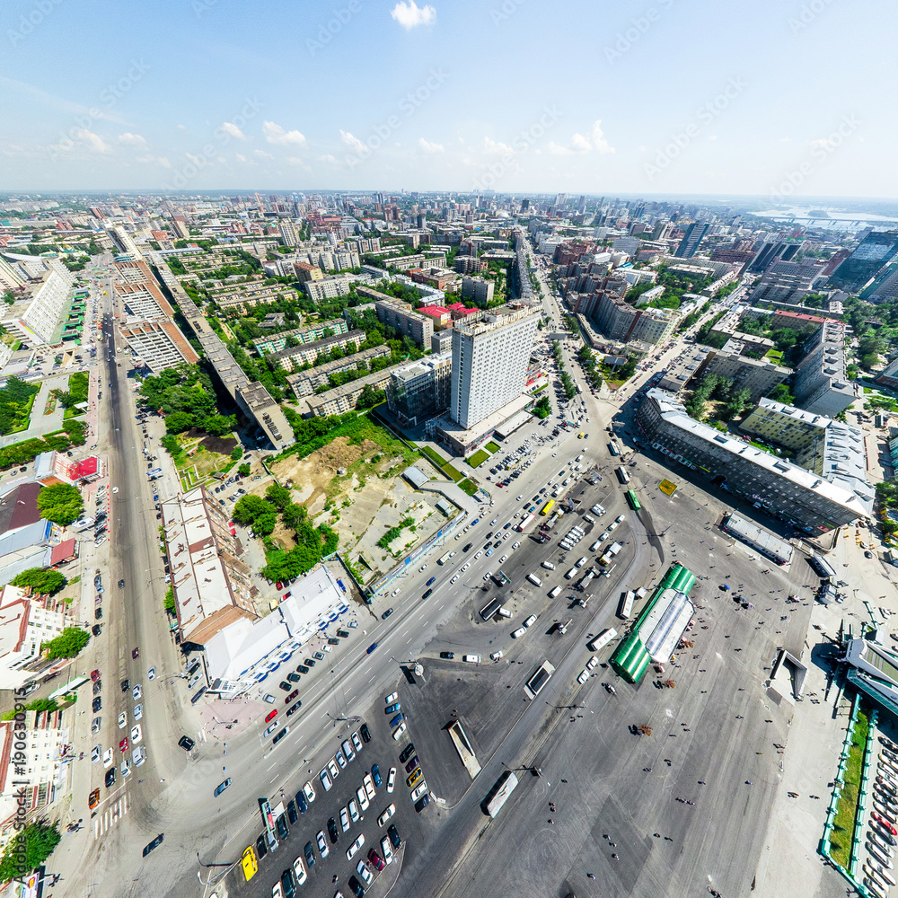 Fototapeta premium Aerial city view with crossroads and roads, houses, buildings, parks and parking lots, bridges. Urban landscape. Copter shot. Panoramic image.