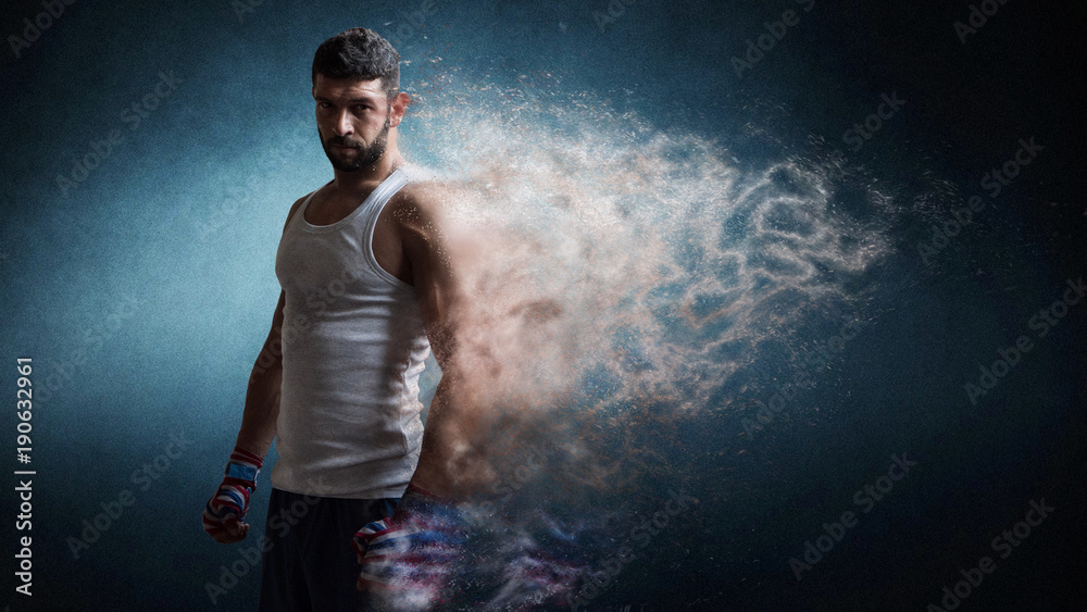 Muscular male boxer standing over dark background particles effect.