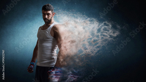 Muscular male boxer standing over dark background particles effect. © Bobboz