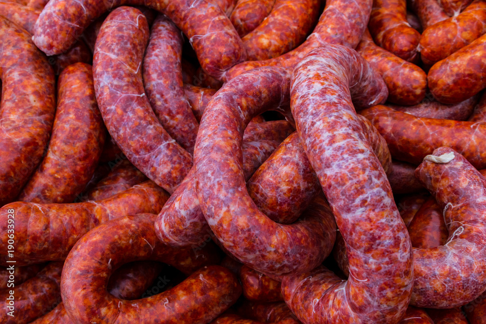 Background with delicious raw peppered pork sausage Background with delicious raw peppered pork sausage