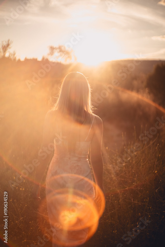 Woman in sunset field of grass