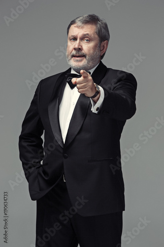 Senior Businessman standing and pointing to camera