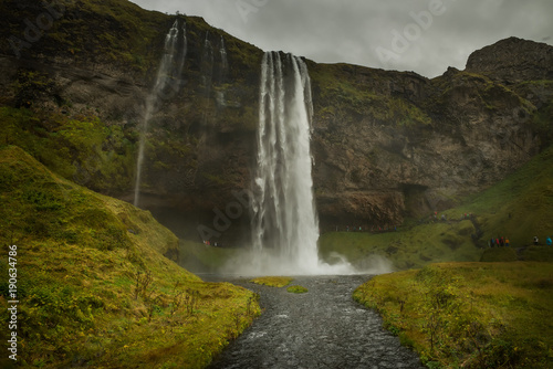 A powerful waterfall among the rocks covered with green moss. Iceland. Dark fabulous atmosphere, vintage.   © Ann Stryzhekin