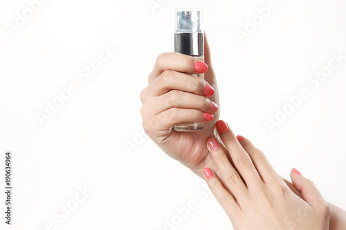 Female well-groomed hands hold a bottle of foundation