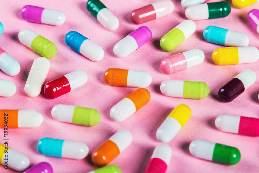 different color pills on a pink background. Drugs and medicines, concept different color pills on a pink background. Drugs and medicines, concept