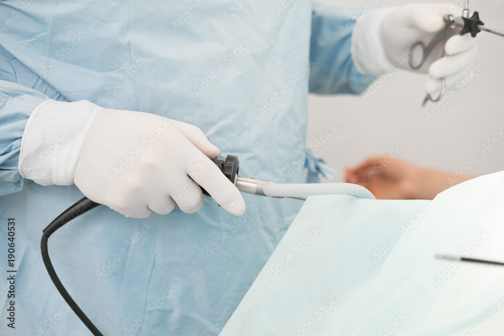 doctor performing surgery on a patient in operation room. instruments for laparoscopy. surgeon operating in hospital or clinic. medicine, emergency concept