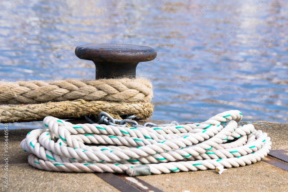 Fototapeta premium Ship mooring ropes secured around a port bollard
