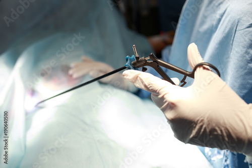 doctor and assistance medical team performing surgery on a patient in operation room. instruments for laparoscopy. surgeon operating in hospital or clinic. medicine, emergency concept