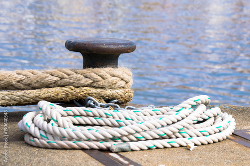 Ship mooring ropes secured around a port bollard