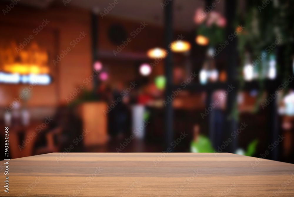 Empty wooden table and blurred background of abstract in front of restaurant or coffee shop for display of product or for montage