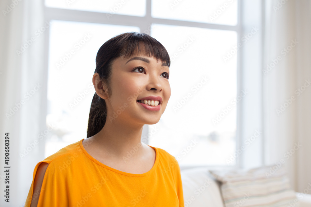 portrait of smiling young asian woman at home