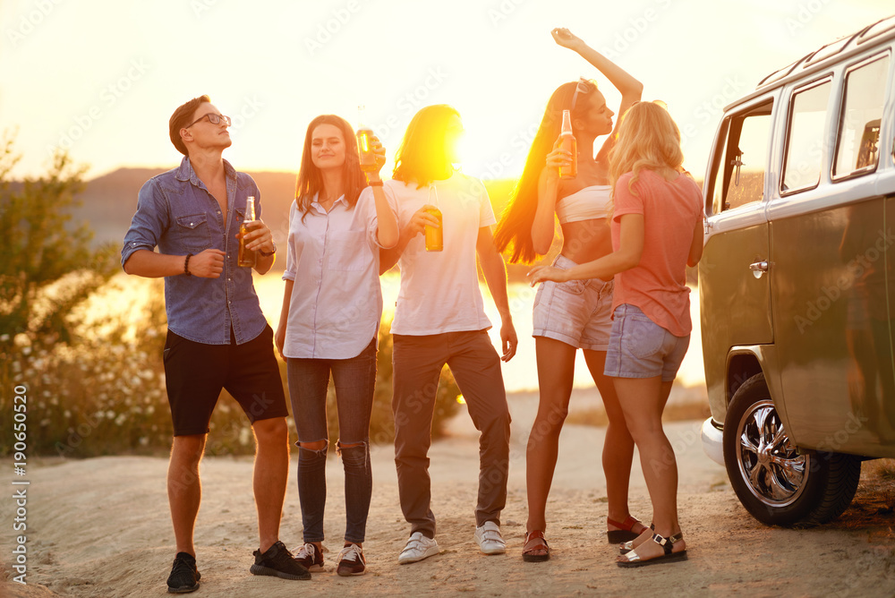 Obraz premium Young Friends Dancing And Drinking In Nature.