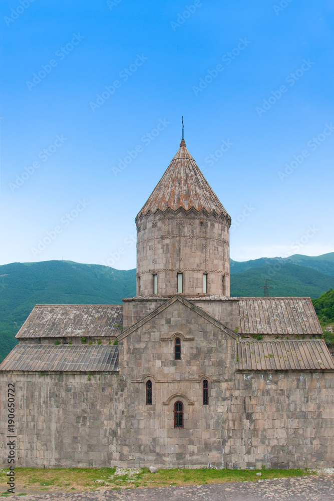 Surb Pogos-Petros Cathedral, Tatev Monastery - Armenian Apostolic Monastery of IX century. Mountains, green hills and clear blue sky. Armenia.	