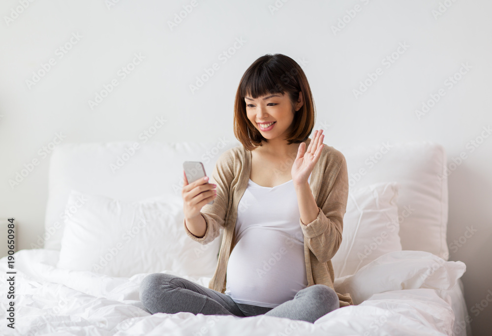 pregnant woman taking selfie by smartphone at home pregnant woman taking selfie by smartphone at home