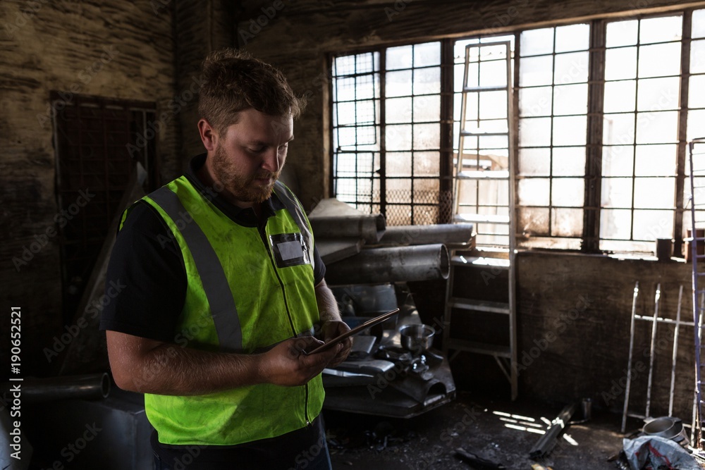 Worker using digital tablet in the junkyard Worker using digital tablet in the junkyard