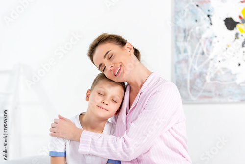 mother and son embracing in pajamas in morning