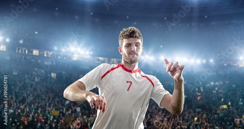 Happy soccer player on a football stadium