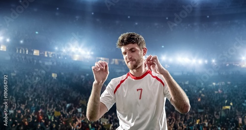 Happy soccer player on a football stadium