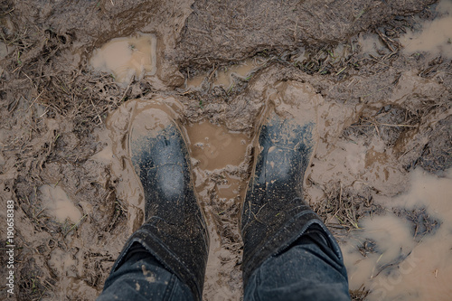 In rubber boots on dirt, at the festival