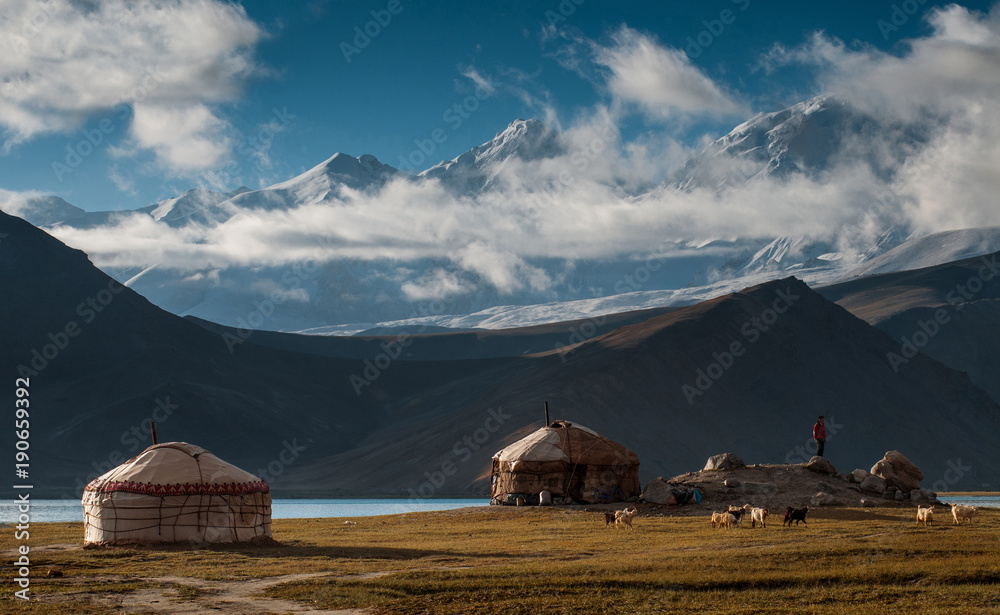 The yurt village in front of Karakul Lake in Xinjiang Uighur Autonomous Region of China is the highest lake of the Pamir plateau, with Muztagh Ata peak of the Kunlun mountains, in the background.